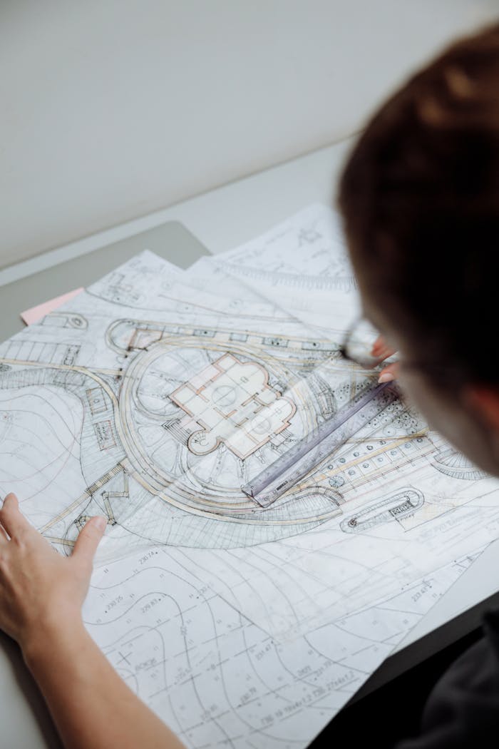 about-us Professional architect analyzing detailed blueprints at a workplace.